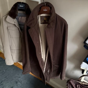 Loro Piana rock - Säljer en Loro Piana rock i choklad brun färg. Den är gjord med det exklusiva menoufi brushed stormsystem fabric med rain & wind protection. Menoufi eller Karnak-Menoufi är det finaste egyptiska bomull som finns på marknaden med långa fina fibrer. Finns mycket mocka detaljer i fickor, krage och insidan. Broderad ”Loro Piana” i kragen. Fungerar alla årstider. Kan inte hitta några märkvärdiga tecken på användning. Pris från butik ligger runt 5000€. Är öppen för prisförhandling. 