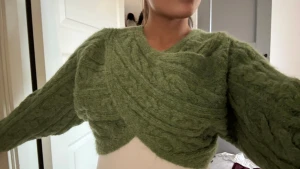 Grön croppad stickad tröja från Zara - Säljer en grön croppad stickad tröja från Zara med snygg omlott-design framtill. Helt ny, med prislappen kvar! Aldrig använd