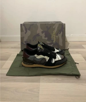 Valentino Rockrunner - Snygga Valentino Garavani Rockrunner sneakers med camouflage-mönster i svart, grått, vitt och olivgrönt. Skorna är i storlek 42, dustbag och box ingår. Skick 7/10