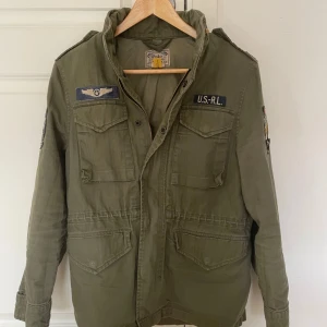 Ralph Lauren Field jacket - En otroligt snygg och eftertraktad field jacket ifrån Ralph Lauren. | en knapp är av men finns kvar, därav priset. |  bra skick. | Kostar cirka 4000-5000 att köpa ny. | Modellen är 180, passar runt 170-182. | Storlek L i ungdom så passar en XS/S. | Hör av er vid frågor!