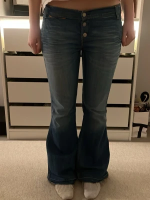 Blå Levis bootcut jeans - Säljer ett par Levis jeans i klassisk blå tvätt med bootcut passform och låg midja. På lappen står det att storleken är 31x32, jag är 171 cm. Hör av dig för frågor!