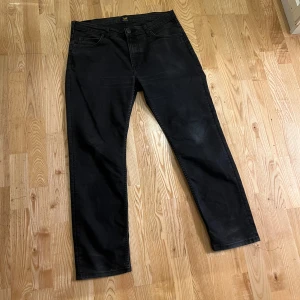 Svarta jeans från Lee - Säljer ett par svarta jeans från Lee med tvättad look i modellen ”RIDER”. Storlek: W36 L32