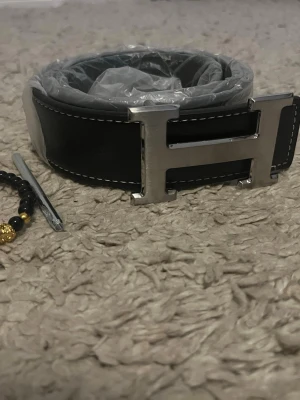 Svart H bälte  - Säljer mitt herrmes bälte 100cm helt nytt. Armband ingår. Hör av er vid frågor och funderingar 