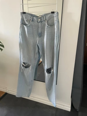 Ljusblå högmidjade jeans  - Ljusblå högmidjade jeans men hål på knäna och vida ben, väldigt bra skick. Från ginatricot i storlek 42. 💕