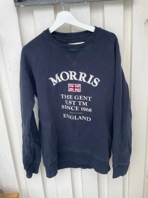 Mörkblå sweatshirt från Morris Gents - Säljer en marinblå sweatshirt från Morris med broderad text och brittisk flagga på bröstet. Tröjan har rund halsringning, ribbade muddar och är tillverkad i mjuk bomull. Perfekt för en avslappnad och stilren look.  Stl S - Herr storlek  Märke: Morris  Använd men mycket fin ändå - se bilder.  #Morris #Märke #herrmode #😍 #klader  #Vinted #uk  #mode  #loppis  #Fashion #SecondhandFinds #retro  #herrkläder  #secondhandstyle#vinteddanmark #vintednorway #nordicbuyers #europeansellers #menswear #unisexf