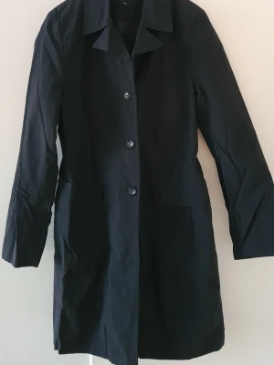 Kappa 38/40 - Kappa i storlek 38/40 midjeformad. Knäpps med knappar.