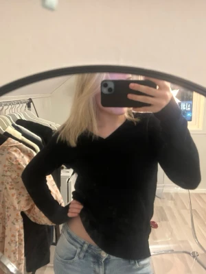 Svart v ringad stickad tröja - Svart stickad tröja med lite vringad hals. Liten tråd som sticker ut på ena armen men inget man ser när man har på sig den