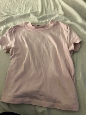 Ljusrosa t-shirt från new Yorker  - Enkel och stilren ljusrosa t-shirt från  new Yorker i storlek M. Klassisk rund halsringning och korta ärmar. Tillverkad i mjuk bomull som känns skön mot huden. Perfekt basplagg att matcha med allt.