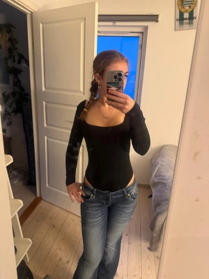 Svart långärmad body med urringning - Säljer en svart, tight och stretchig topp med lång ärm och urringning från zara