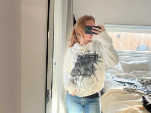 Vit Diesel hoodie med svart graffiti-tryck - Säljer en vit hoodie med svart graffiti-inspirerat tryck på framsidan. Tröjan har snörning vid huvan och är långärmad. Materialet känns som mjuk bomull och passformen är normal. Se defekter på de två sista bilderna! Jag på bilden brukar bära XS som referens!