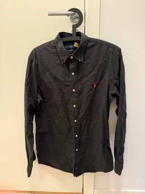 Svart Ralph Lauren skjorta slim fit - Säljer nu min svarta Ralph Lauren skjorta i hel svart. Den är i mycket bra skit och är väldigt stilren. Mycket bra passform också! Nu pris runt 1200kr och kan prutas!