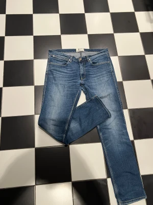 Blå Acne Studios jeans slim fit - Snygga blå jeans från Acne Studios med klassisk femficksdesign och diskret tvättad look. Modellen är slim fit med lite tightare midja skulle säga att de sitter som en 31 och raka ben. Jeansen är tillverkade i mjukt bomullsmaterial med stretch för extra komfort. Perfekta för dig som gillar stilrena och moderna jeans. Modellen är 185cm och väger cirka 75kg. Pris går att diskutera!