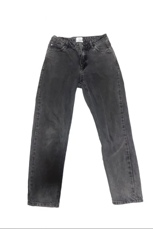 Svarta raka jeans från Grunt - Snygga svarta jeans från Grunt med rak passform och klassisk femficksdesign. Jeansen har en normal midja och är tillverkade i mjukt denimtyg som ger en cool och avslappnad vibe. Perfekta för dig som gillar en enkel och stilren look.