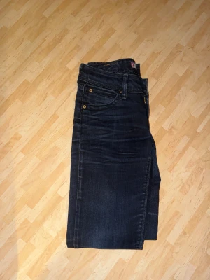Levi's 571 mörkblå slim fit jeans - Säljer ett par Levi's 571 jeans i mörkblå tvätt med slim fit passform. Klassisk femficksdesign, guldfärgade nitar och Levi's röda logotagg på bakfickan. Jeansen är tillverkade i stretchigt denim för extra komfort och har en modern, smal siluett.