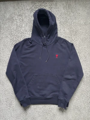 Mörkblå hoodie från Ami Paris - Tja, säljer en  äkta mörkblå Ami Paris hoodie i storlek M, tröjan är i väldigt bra skick och har inte några defekter, modellen är 187 cm, väldigt eftertraktad hoodie så kom privat vid minsta lilla och pris går självklart att diskutera vid snabb affär💯🍾🥂