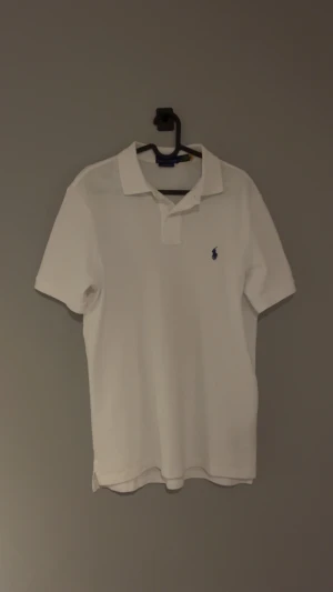 Ralp Lauren pique  - en vit pique från ralp lauren med blåt märke. använt en gång men har inga tecken på användning.