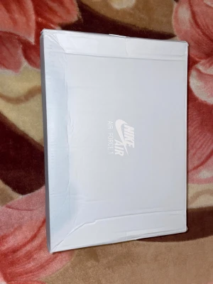 Nike Air Force 1 helvita sneakers - Fräscha Nike Air Force 1 sneakers i helvitt skinn med klassisk siluett och platt sula. Modellen har snörning, perforerad tå och ikoniska swoosh-loggan på sidorna. Perfekt för dig som gillar cleana och tidlösa sneakers med streetkänsla.