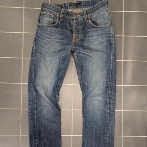 Dry Selvadge Lab Tim22 30/32 - Sjukt feta och exklusiva Nudie Lab Tim 22 I storlek 30/32. Uppsydda ca 5 cm vilket gör att lappen inte riktigt stämmer. Lab tim som kommer färdig tvättade från fabrik och som är Nudies top of the line kollektion. Riktigt bra skick för sin ålder och kommer hålla sin fabrikstvätt länge. 1900 eller rimligt bud.