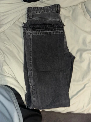 Flared Jeans Zara - Snygga svarta jeans med rå, fransad kant upptill för en edgy vibe. Modellen har klassiska fem fickor och raka ben. Jeansen är tillverkade i ett slitstarkt denimtyg och har en mörk tvätt som ger en cool look.