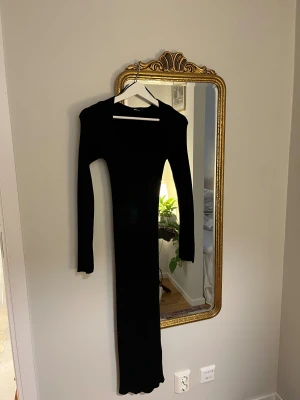 Svart ribbad långklänning Gina Tricot - Säljer en svart, ribbad långklänning från Gina Tricot. Klänningen har lång ärm, v-ringad urringning och sitter tight mot kroppen. 