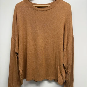 Brun stickad tröja från Sansa Collection - Mysig brun stickad tröja från Sansa Collection i storlek L. Tröjan har en rund halsringning och långa ärmar med avslappnad passform. Perfekt för dig som gillar en enkel och chill stil med lite oversized känsla.