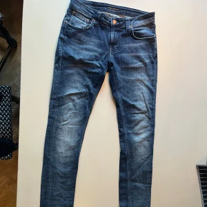 Mörkblå slim jeans från Nudie Jeans - Säljer ett par mörkblå slim jeans från Nudie Jeans med snygga slitningar. Jeansen är tillverkade i stretchig denim. Om ni har några frågor är det bara att skriva till mig