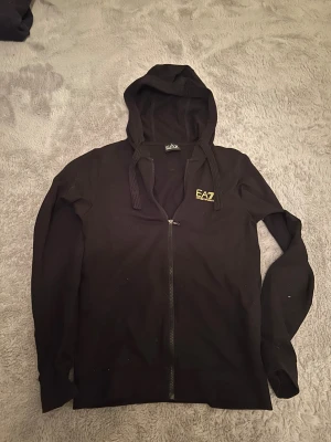 Svart EA7 hoodie med dragkedja - Äkta Emporio Armani hoodie köpt i butik för 1499kr säljer endast för ett jättebra pris för en skit snygg använd knappt eftersom den har blivit för liten för mig