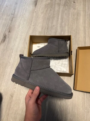UGG MINI / GRAA - Säljer dessa UGG Tasman. De är helt nya och oanvända, och lådan medföljer. Jag står för äktheten till 100%. Jag accepterar ENDAST betalning via PayPal, och jag skickar varje dag fram till 20:00 - Jag har över 100+ 5-stjärniga recensioner på Vinted, så oroa dig inte! ☺️