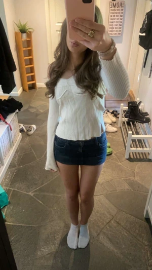 Mörkblå jeanskjol i minilängd - Säljer en snygg mörkblå jeanskjol i minilängd med klassisk femficksdesign och knapp framtill. Kjolen har en tight passform och är perfekt för dig som vill ha en enkel men trendig look. Passar till allt och är ett måste i garderoben!