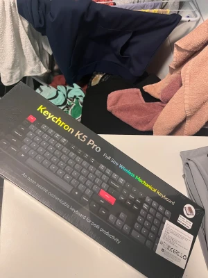 Keychron K5 Pro - Keychron K5 Pro är ett fullstort trådlöst mekaniskt tangentbord med lågprofilsswitchar. Kompatibelt med både Mac och Windows, kan anslutas till upp till 3 enheter. Oöppnad förpackning, nyskick. Perfekt för produktivitet och anpassningsbar via webben.