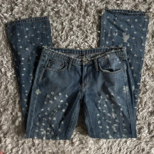 Bootcut jeans med lågmidja och slitningar - Sjuuukt snygga jeans med lågmidja i en bootcut modell med coola slitningar. Superfint skick och verkligen one of a kind!