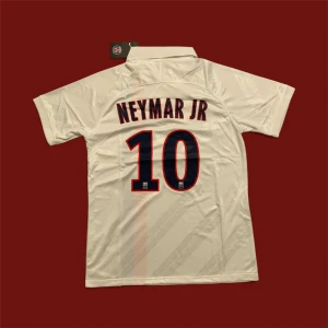 PSG Neymar Jr 10 vit matchtröja Nike - Säljer en vit PSG matchtröja med Neymar Jr och nummer 10 på ryggen. Tröjan har korta ärmar, krage och tryck i marinblått och rött. Framsidan har PSG-logga, Nike-logga och sponsortryck samt en vertikal röd och marinblå rand. Perfekt för fotbollsfans!