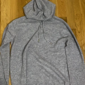Kashmere Hoodie (Helt Ny!) - Säljer denna supersnygga och fräscha gråa hoodie gjord av 100% Kashmir. Aldrig använd och köptes för 1 700 av ett UF-företag pa julmarknad. Normal passform och perfekt för en avslappnad look. Kan gå ner i pris vid snabbt affär. Storleken är storlek S