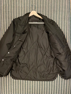 Lätt dunjacka från Rose & Born - Fin olivgrön jacka från Rose & Born i storlek 48 vilket känns som en S. Jackan är i mycket bra skick och har inga anmärkningar.