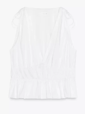 Vit omlottopp med knyt på axlar - Zara. Säljer en fräsch vit omlottopp med knytband på axlarna och volangkant nedtill. Toppen är ärmlös och har en lätt v-ringad omlottdesign som ger en luftig känsla. Perfekt för varma dagar och enkel att styla till olika looks.