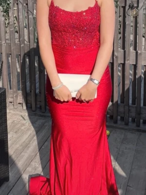 Bal klänning  - Röd långklänning med smala axelband och öppen rygg. Klänningen har blommig spets upptill och är dekorerad med små glittriga stenar över hela tyget, tight passform. Klänning är köpt från zapaka, använd vid ett tillfälle så är i bra skick, storleken är 6 passar mig perfekt som har s i storlek 
