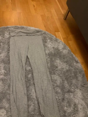 Grå leggings från Gina Tricot - Mjuka och stretchiga grå leggings från Gina Tricot. De har en enkel design med hög midja och är tillverkade i ett tunt och bekvämt bomullsmaterial. Perfekta för en chill och avslappnad stil.