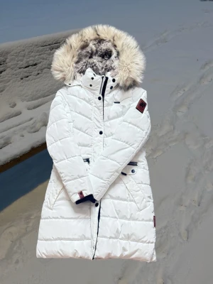 Vit lång vinterjacka med fuskpäls – varm & stilren i storlek small från Zalando - 🧥 Produktbeskrivning 🧥Snygg och varm vit vinterjacka i längre modell. 🧥Köpt från Zalando — varumärket är Navahoo och modellen är PAULA. 🧥På Zalando säljs den för 1.789kr. 🧥Bröstmått: ca 102cm (51cm x2). 🧥Längd på jackan:  ca 87cm — alltså till låret. 🧥Perfekt för kalla vinterdagar och riktigt snygg passform. 🧥Jackan har en stor, fluffig fuskpälsluva som ger en lyxig känsla samtidigt som den håller dig riktigt varm under vintern.  🧥Pälsen är avtagbar, vilket gör jackan lätt att anpassa efter stil