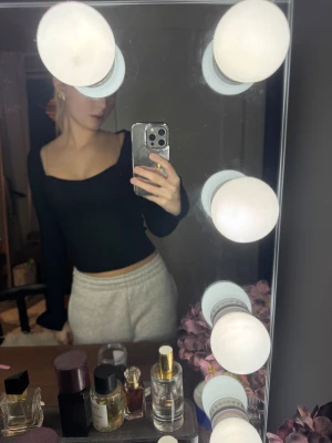 Svart ribbad långärmad topp - Säljer en svart ribbad topp med lång ärm och fyrkantig ringning. Modellen är croppad och sitter tight mot kroppen. Perfekt att styla med både jeans och kjol för en trendig look.