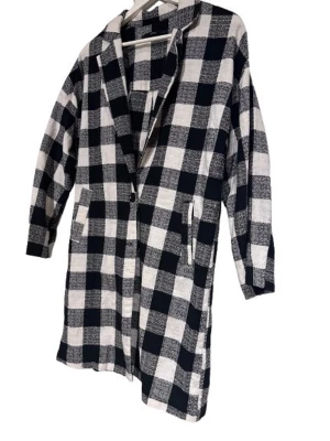 Rutig lång kavaj från ECRU - Säljer en svartvit rutig lång kavaj från ECRU. Jackan har klassisk krage, knäppning framtill och två fickor. Materialet känns lätt och har en snygg struktur. Perfekt för dig som gillar statement-plagg med oversized känsla.