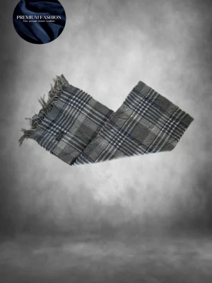 Grå Burberry Halsduk - Tja! Säljer en klassisk halsduk från Burberrys i grått, blått och vitt rutmönster. Halsduken är tillverkad i 100% lammull och har tvinnade fransar i ändarna. Perfekt accessoar för att soppa upp vinterlooken med en tidlös skön outfit! Denna färg är rätt sällsynt men fortfarande väldigt snygg enligt mig🤩skicket är 10/10 alltså som ny kortfattat! Den passar bra till allt och är bara allmänt snygg🤗denna modell är vintage och slutade tillverkas senast 1999! Hör av dig vid fråga! Mvh premium fashion🤗