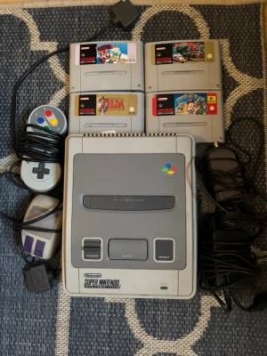 Super Nintendo Entertainment System (SNES) PAL - 🫶🎄Komplett Super Nintendo Entertainment System (SNES) PAL med två originalkontroller, strömadapter och fyra spel: SUPER mario paint , The Legend of Zelda: A Link to the Past, Super Street Fighter II och Adventure Island. Konsolen och tillbehören visar normalt bruksslitage men är i gott skick. OBS KONTAKTA MIG INNAN KÖP!  SÅ DET BLIR RÄTT FRAKT HELST MED  SCHENKERN DOM HAR seriös Service  POSTNORD är Slarviga. Vid intresse  lämnar ut tel nummer!  ! Hämta garna upp  varan i Gbg. 