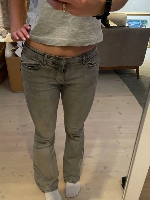 Grå bootcut jeans från Gina Tricot  - Gråa, lågmidjade bootcut jeans från Gina Tricot. Storleken är 38. 