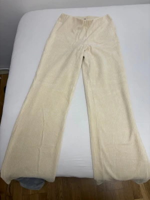 Vita manchesterbyxor från Amisu - Säljer ett par ljusa, vita manchesterbyxor från Amisu i storlek S. Byxorna har raka ben och hög midja, med breda ribbor som ger en snygg retrovibe. Perfekta att styla med en croppad topp eller stickad tröja.