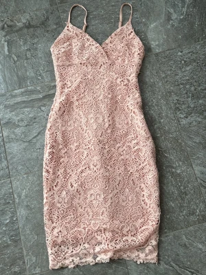 Ljusrosa spetsklänning från Bik Bok - Säljer en ljusrosa spetsklänning från Bik Bok i storlek S. Klänningen är kort, figurnära och har smala axelband samt v-ringad hals. Spetsmaterialet ger en romantisk och feminin känsla med fina detaljer längs nederkanten. Har en ytterst liten fläck den syns på bild två❤️