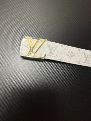 Vit bälte med guld logga - Helt ny! 110cm. Skickad med skydd. Extra bra kvalitet!