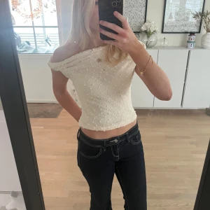 Offshoulder vit topp med struktur - Säljer en superfin offshoulder topp i vit färg med diskret prickig struktur. Toppen har en figurnära passform. Materialet känns lätt och luftigt, perfekt för varmare dagar eller när du vill ha en stilren look. (Aldrig använd)