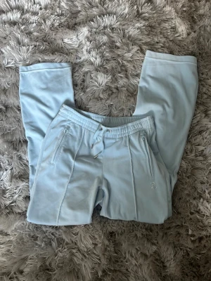💎 Juicy Couture ljusblå mjukisbyxor – som nya ✨ -  Säljer ett par ljusblå Juicy Couture byxor i storlek S 🤍 Byxorna är i nästintill nyskick, knappt använda och utan tydliga tecken på slitage.  ✨ Detaljer: 	•	Original Juicy Couture 	•	Ljusblå färg 	•	Glittrande Juicy-logga baktill & liten JC-logga framtill 	•	Dragkedjefickor 	•	Mjuk och bekväm passform 	•	Snygga både till vardags och som cozy outfit  Perfekta om du vill ha klassiska Juicy-byxor i fint skick 💕 Skickas snabbt. Hör av dig vid frågor eller fler bilder!