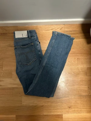 Blå Tiger of Sweden jeans skinny fit - 28/30 - Säljer ett par klassiska blå jeans från Tiger of Sweden. Modellen har skinny passform, fem fickor och normal midja. Jeansen är tillverkade i mjukt denimtyg med snygg tvätt och subtila slitningar. Perfekta till sneakers eller boots.