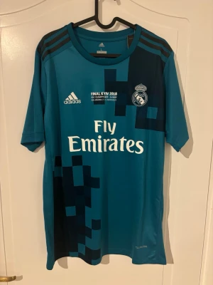 Real Madrid 2017-2018 Tredjetröja  - Säljer denna Real Madrid tröja då den är för liten för mig. Helt ny aldrig använt och är ikonisk. Vid frågor är det bara att skriva.